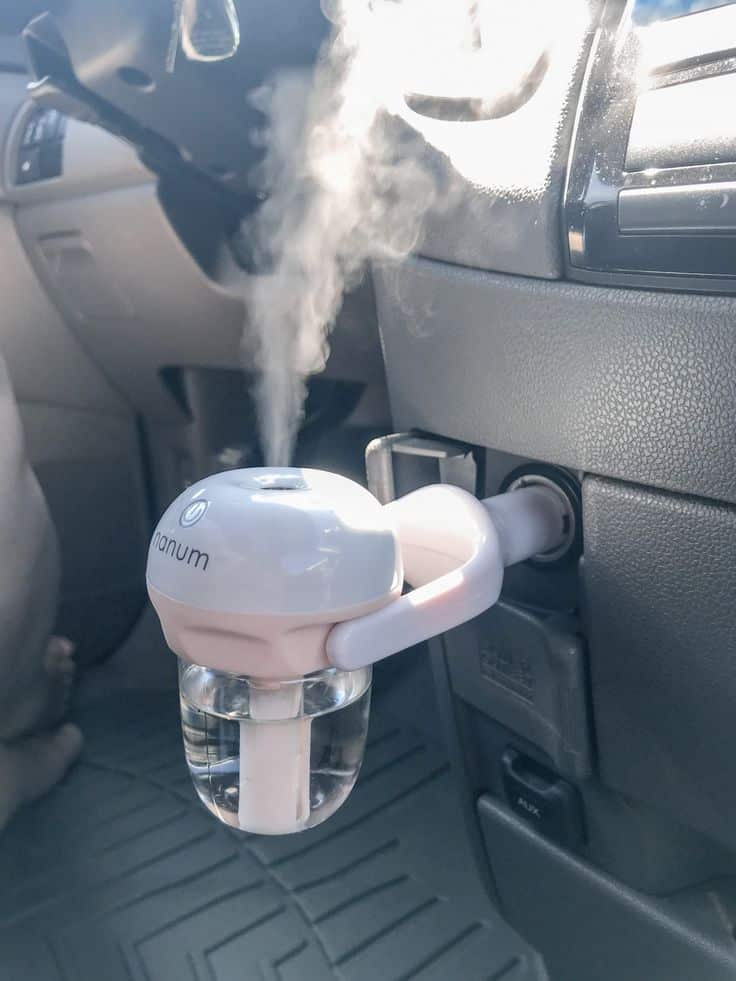 Car air humidifier plugged in, releasing steam for fresher air during travel. Perfect for car interior hydration.