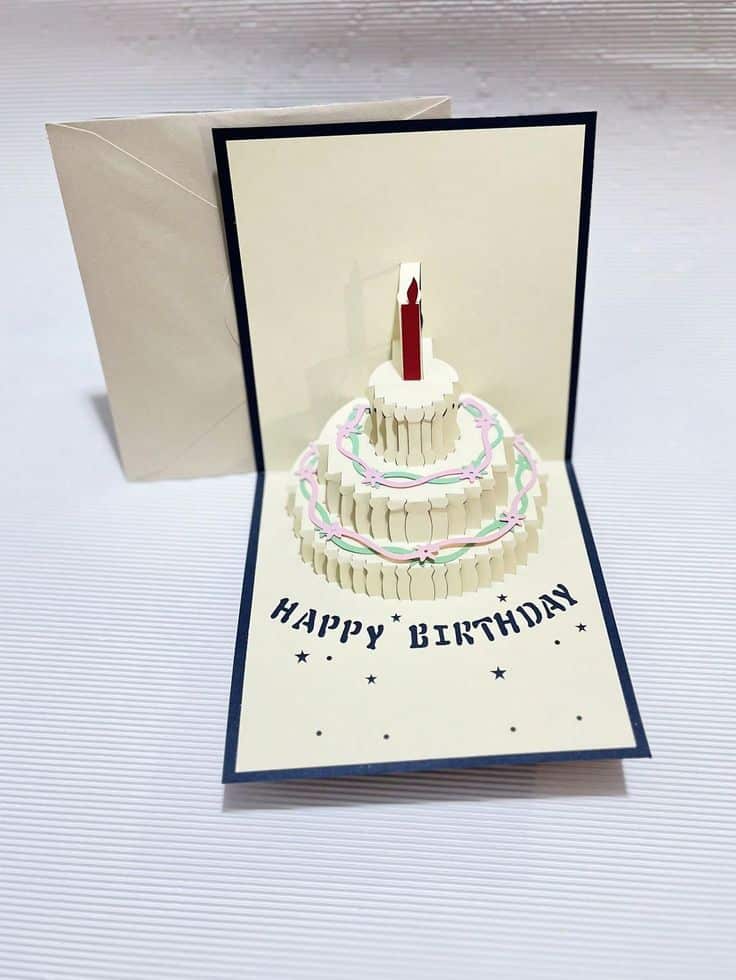 Pop-up birthday card with 3D cake and candle design, featuring Happy Birthday text, perfect for celebrations.