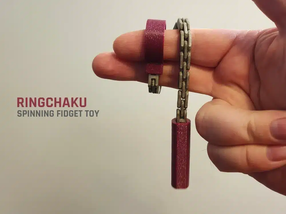 Hand holding a Ringchaku spinning fidget toy with maroon grips and metal chain links.