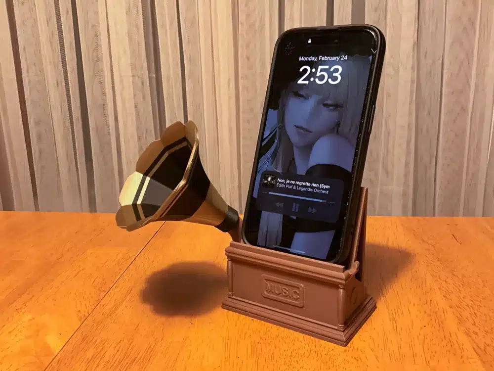 Vintage-style smartphone amplifier dock with gramophone horn on a wooden table.