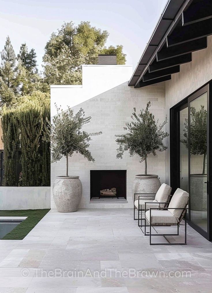 Modern patio with fireplace, large planters, and seating, offering a sleek and minimalist outdoor design.