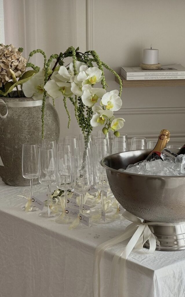 Elegant floral champagne setup with glasses and ice bucket, perfect for a sophisticated event or celebration.
