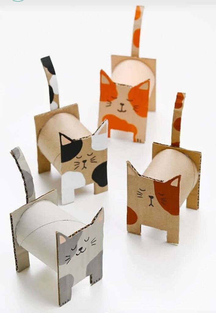 Cardboard tube cats with painted faces and tails, showcasing a fun DIY craft project for feline enthusiasts.