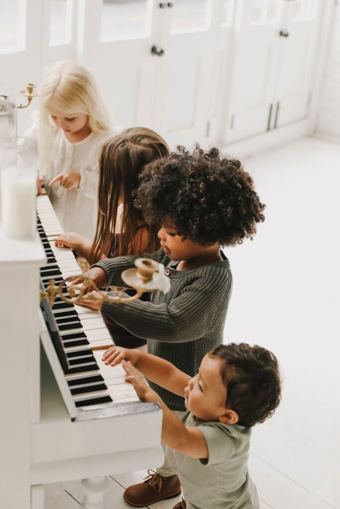 Children playing a piano together in a bright room, enjoying music and creativity.