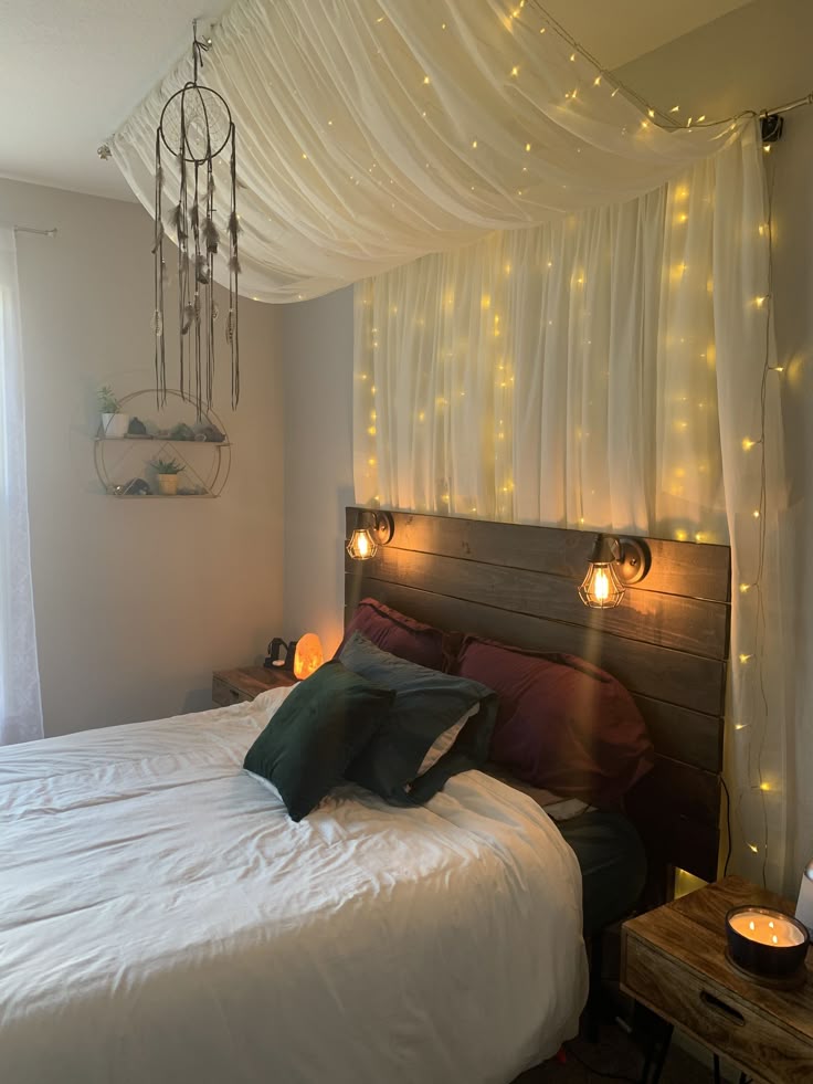 Cozy bedroom with string lights, a dreamcatcher, wood headboard, and plush bedding for a warm, inviting ambiance.
