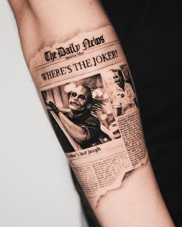 Tattoo of a newspaper featuring Where's the Joker? headline and images on forearm.