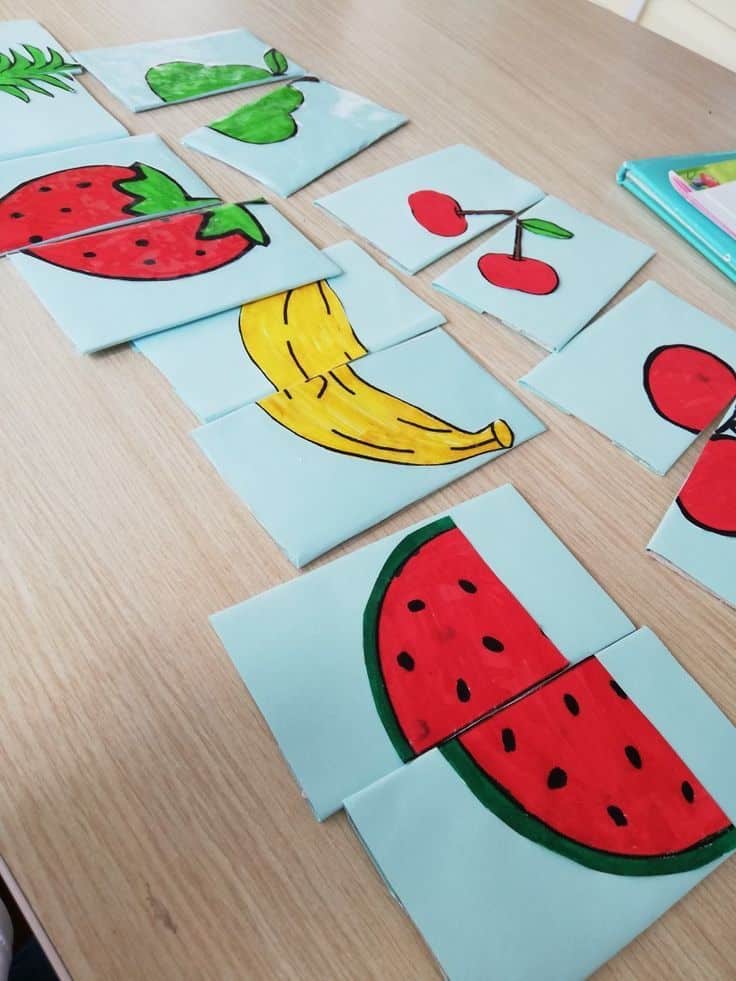 Colorful fruit split puzzles on a wooden table for a fun educational activity.