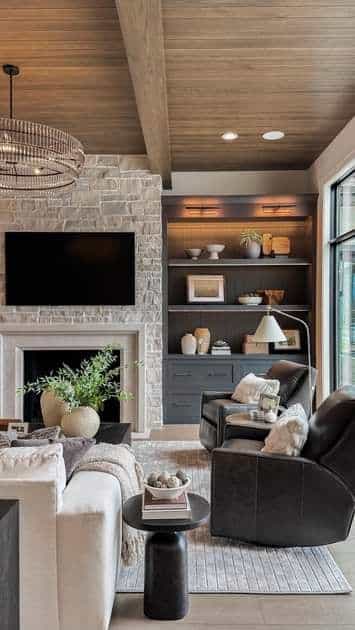 2K views 2_4K reactions _ These evening Showcase Modern living room with stone fireplace, TV, cozy seating, and elegant decor on wooden shelves. | Sky Rye Design Modern living room with stone fireplace, TV, cozy seating, and elegant decor on wooden shelves.