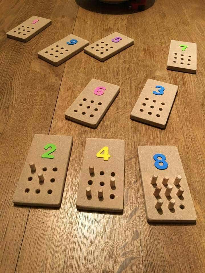 Wooden counting boards with colorful numbers and pegs on a table, designed for educational activities and learning.