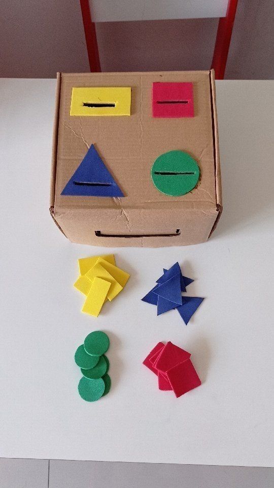 Cardboard shape sorter with colorful geometric pieces for kids' learning and play.