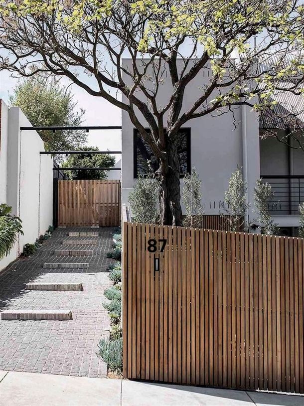 _ 33 Modern home entrance with wooden fence and gate, tree, and landscaped path leading to front door. House number 87 visible. | Sky Rye Design Modern home entrance with wooden fence and gate, tree, and landscaped path leading to front door. House number 87 visible.