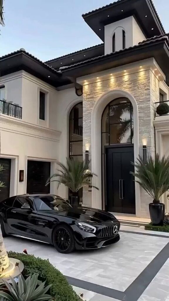 Luxury black car parked in front of a modern mansion at dusk, highlighting elegant architecture and sleek design.