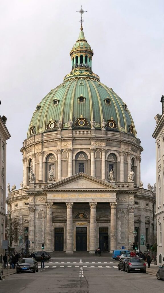 Majestic marble church with a green copper dome in city center, featuring ornate architecture and classical columns.