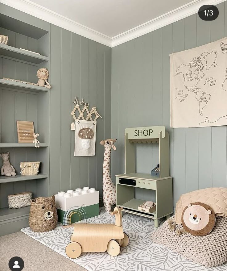 Stylish kids' playroom with green walls, wooden toys, animal decor, and a world map tapestry. Cozy and modern design.
