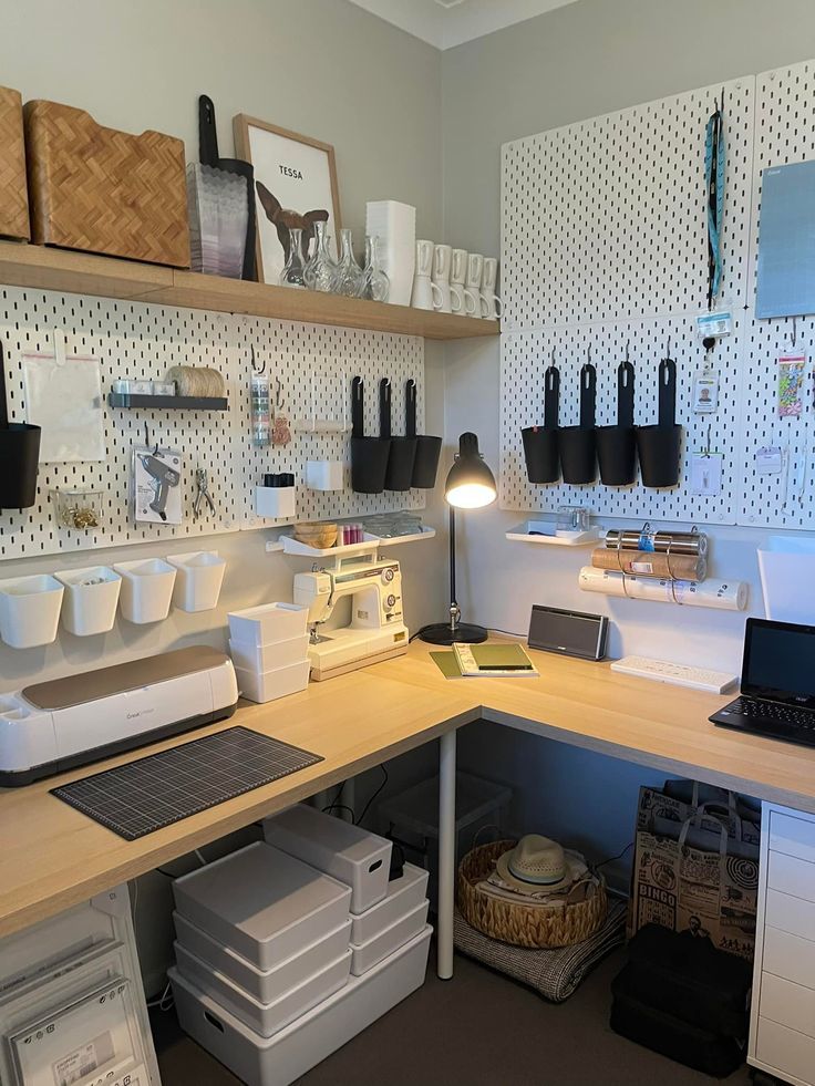 Craft room with organized storage, desk, laptop, sewing machine, and pegboard for tools and supplies.