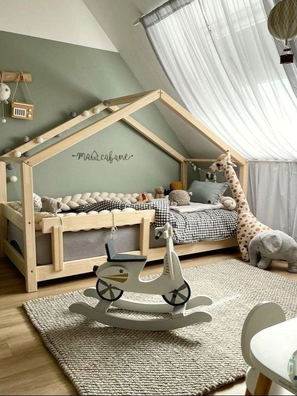 Cozy kids bedroom with house bed, plush animals, rocking horse, and soft lighting for a playful, inviting space.