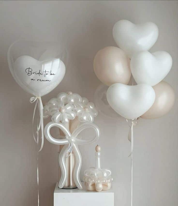 Elegant bridal balloon arrangement with heart-shaped white and gold balloons and creative designs.