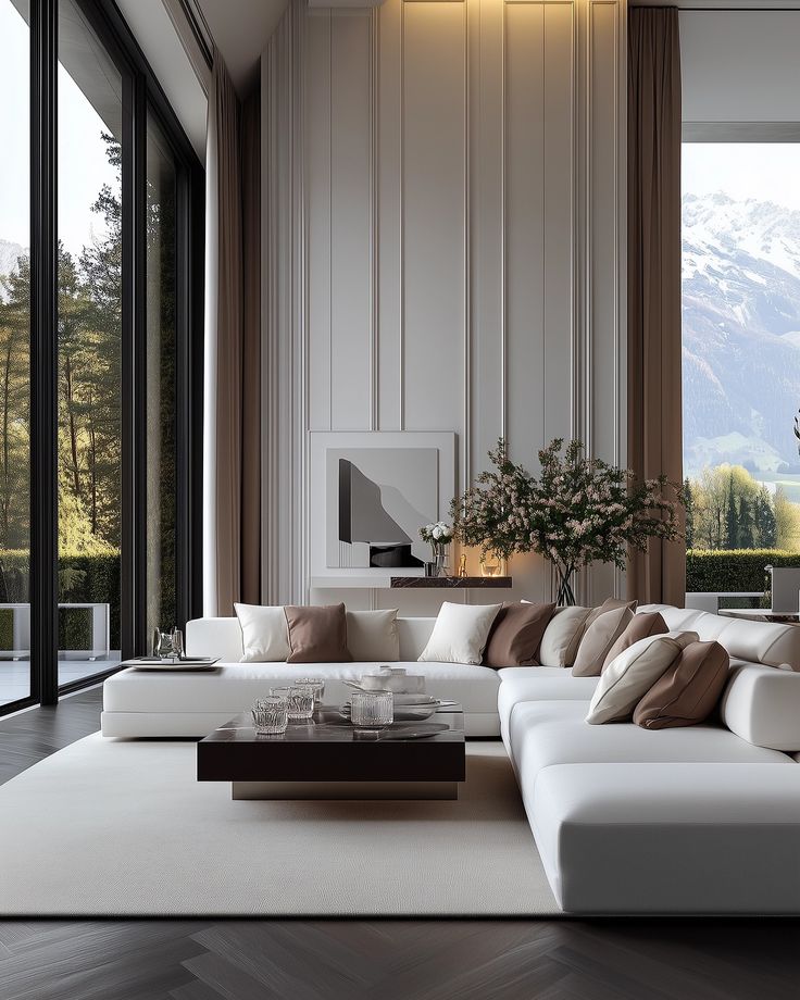 Luxurious modern living room with white sectional sofa, mountain views, and floor-to-ceiling windows.