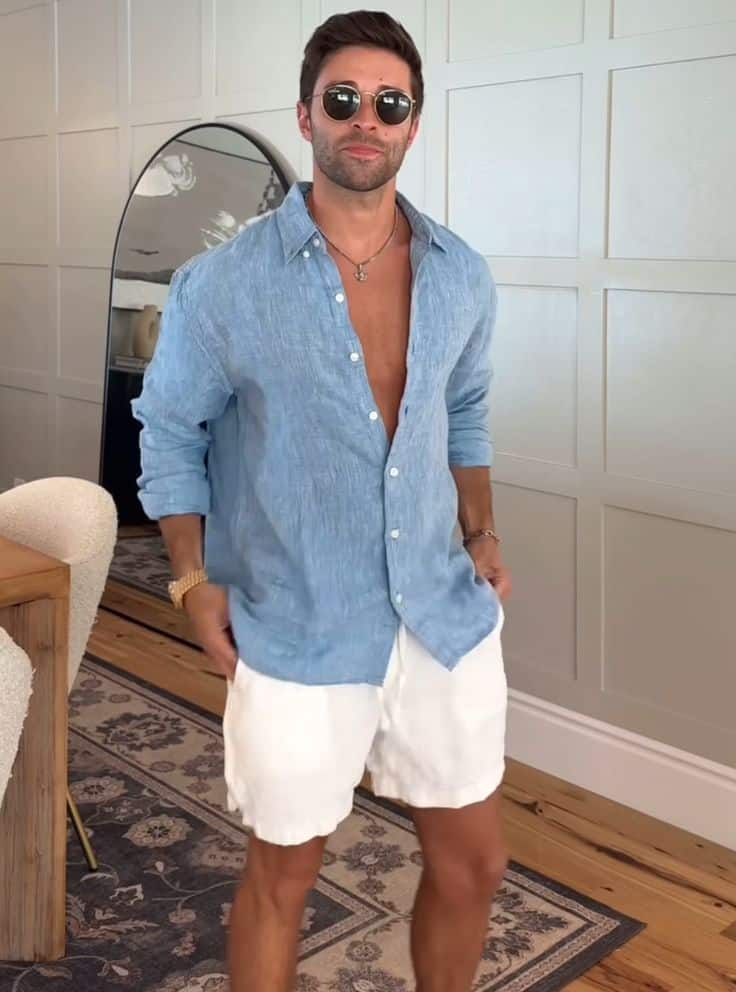 _ 5 Man in casual summer outfit with blue shirt and white shorts, standing indoors, wearing sunglasses, looking confident. | Sky Rye Design Man in casual summer outfit with blue shirt and white shorts, standing indoors, wearing sunglasses, looking confident.