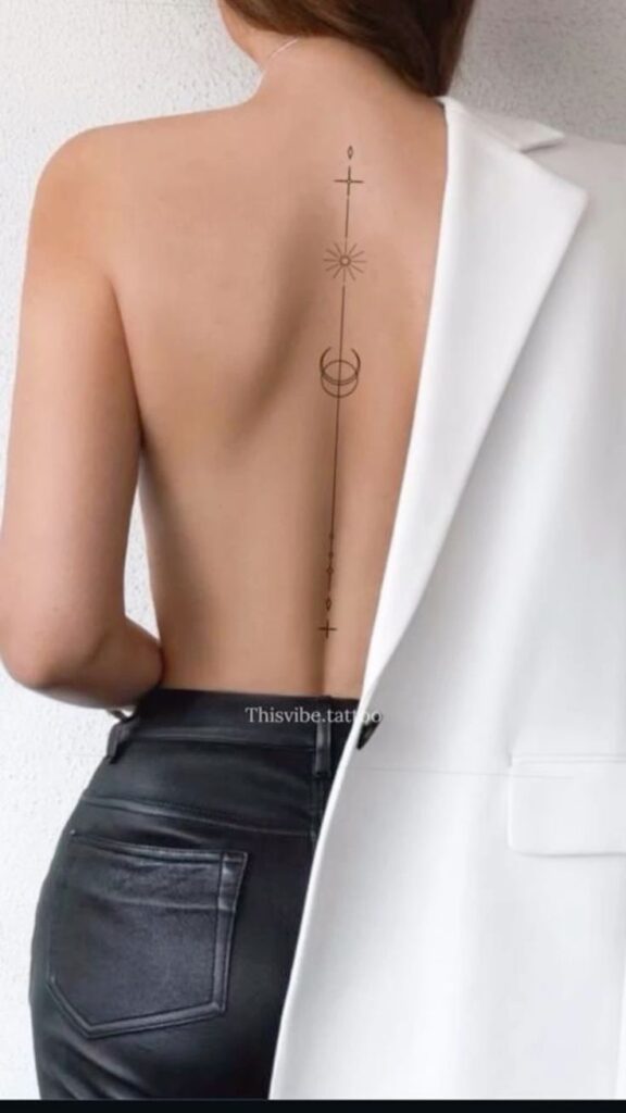 Minimalist back tattoo design with geometric shapes, crescent moon, and star on a woman's bare back, white jacket draped.