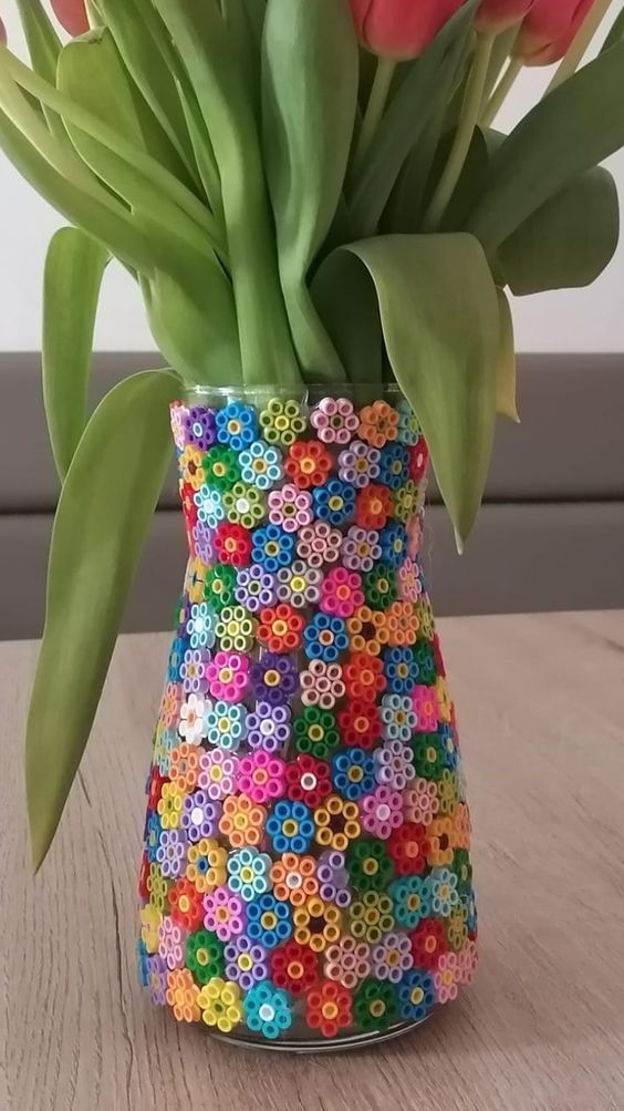 Colorful flower pattern vase with tulips on a wooden table.