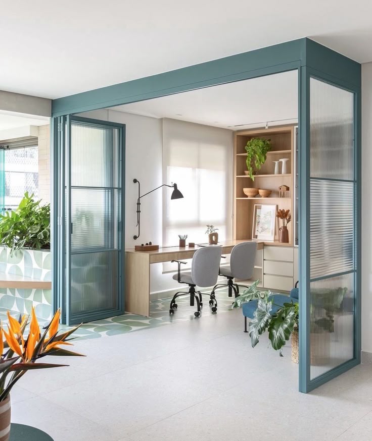 Modern home office with glass partitions, wooden desk, chairs, and plants for a bright and stylish workspace ambiance.