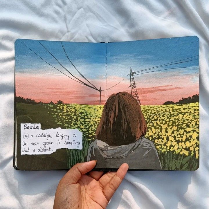 Open sketchbook showing a painted sunset, power lines, and a person in a field with the word Saudade and its meaning.