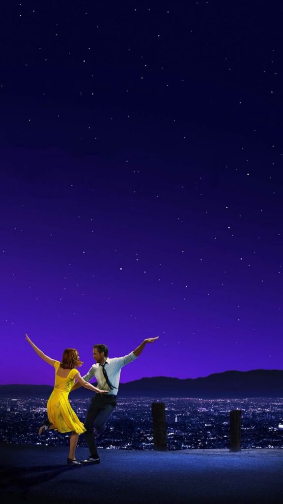Couple dancing under a starry purple sky with a cityscape in the background.