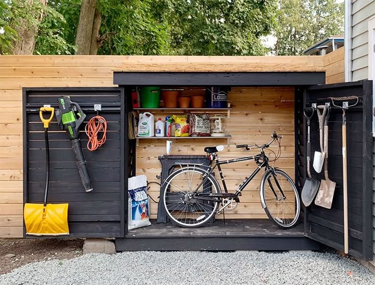 Outdoor shed with garden tools, bike, and supplies neatly organized against a wooden wall.