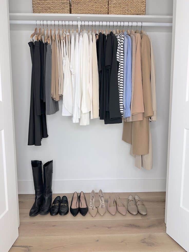 _ 70 Neatly organized minimalist wardrobe with various neutral clothing and shoes, including coats and boots. | Sky Rye Design Neatly organized minimalist wardrobe with various neutral clothing and shoes, including coats and boots.