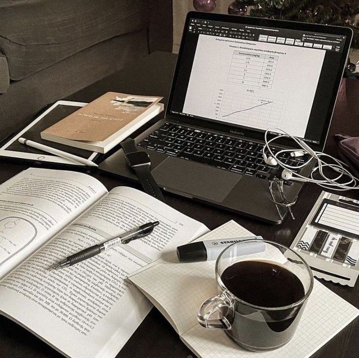 Workspace with a laptop, open notebooks, books, and coffee. Ideal for studying or remote work.