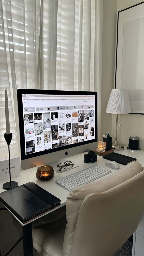 Modern home office setup with desktop computer, keyboard, and stylish decor in natural light.