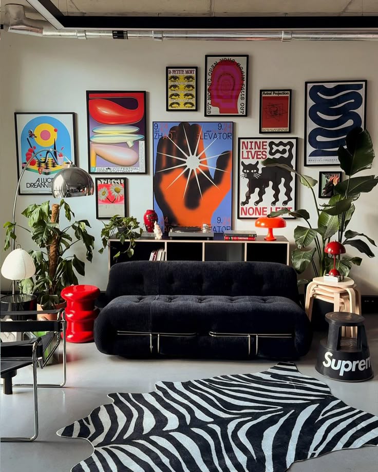 Modern living room with vibrant posters, plants, a black sofa, and a zebra-patterned rug.