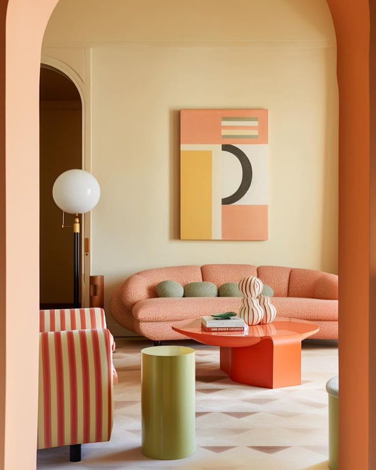 Modern living room with peach sofa, abstract art, and orange accents, featuring minimalist decor and geometric shapes.