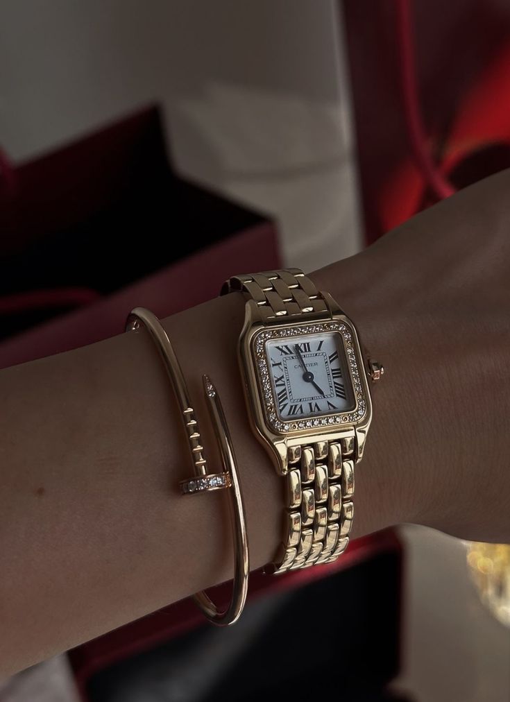 Gold wristwatch and bracelet on wrist, elegant luxury style accessory close-up.