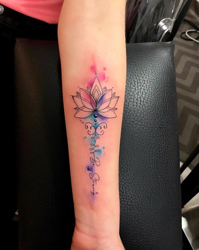 Colorful lotus flower tattoo on forearm with geometric accents and watercolor splashes.