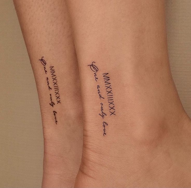 Matching tattoos with Roman numerals and One and only love text on skin, symbolizing everlasting connection.