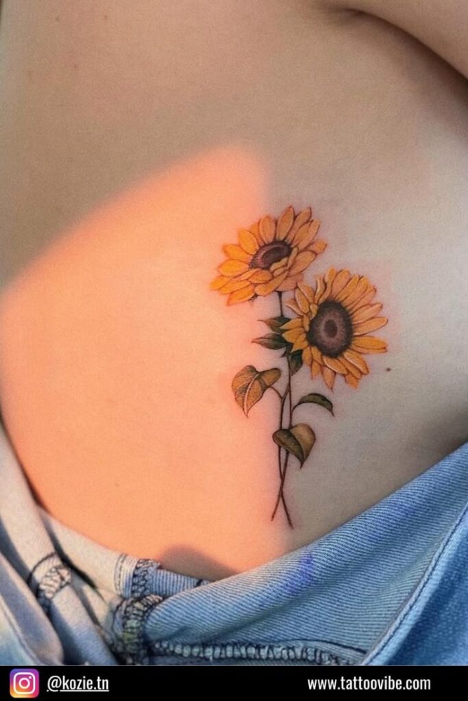 Sunflower ribs tattoo on person wearing jeans, showcasing bright, intricate yellow floral design.