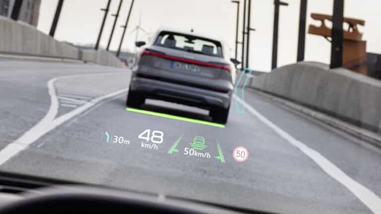 Audi Q4 e-tron Car with augmented reality display showing speed, distance, and navigation on windshield. | Sky Rye Design Car with augmented reality display showing speed, distance, and navigation on windshield.