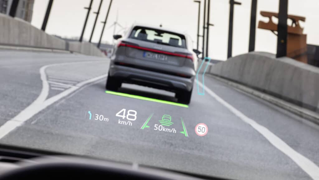 Car HUD display on road showing speed, distance, and navigation information.