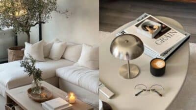 Cozy living room with white sofa, coffee table, books, candle, and potted plant; stylish modern decor.