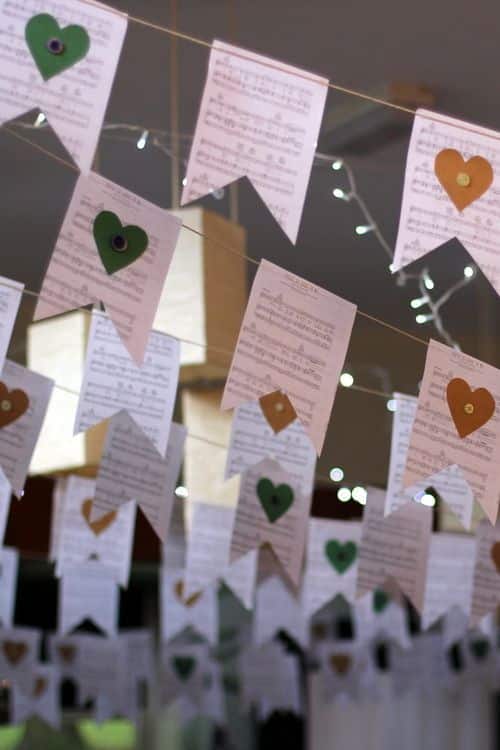 Hanging decorative flags with hearts, featuring musical notes and warm lighting, creating a festive ambiance.