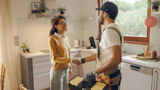 Best Emergency Plumbing Companies in Toronto Available Woman shaking hands with a handyman in a modern kitchen, discussing home repairs and maintenance tasks. | Sky Rye Design Woman shaking hands with a handyman in a modern kitchen, discussing home repairs and maintenance tasks.