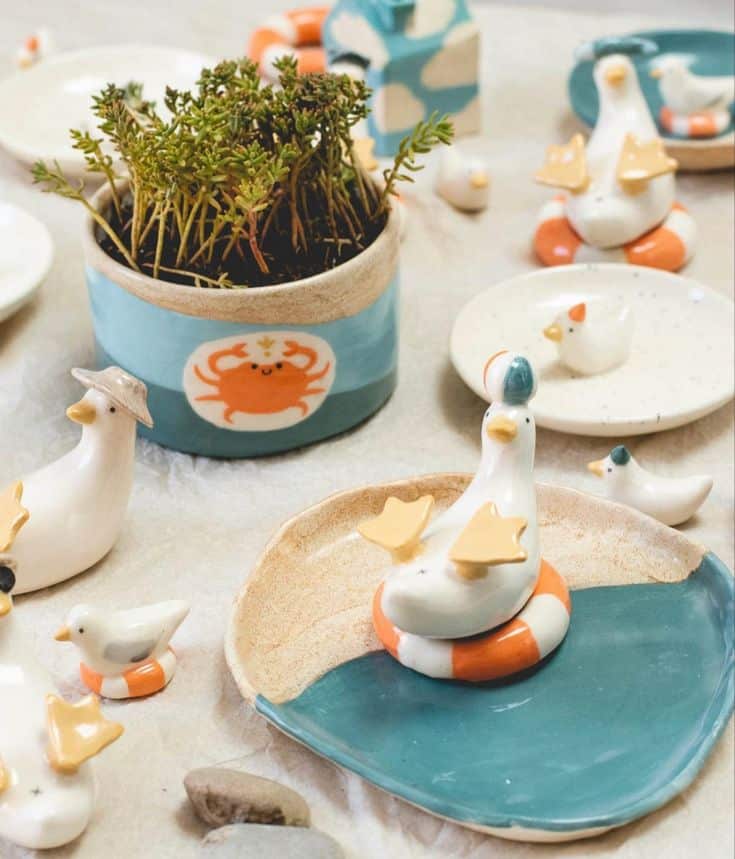 Ceramic duck and plant decor set with blue and orange accents, featuring playful seaside motifs.