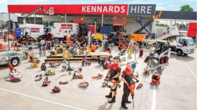 Outdoor display of construction equipment and machinery at Kennards Hire store with staff showcasing tools.