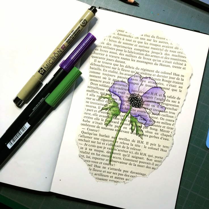 Illustrated purple flower drawn on book page with pens on the side, showcasing creative mixed media art techniques.