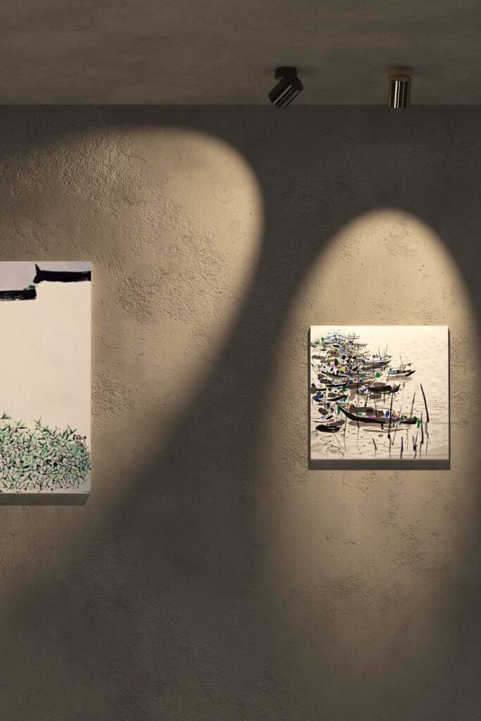 Art gallery with two illuminated paintings on a textured wall.