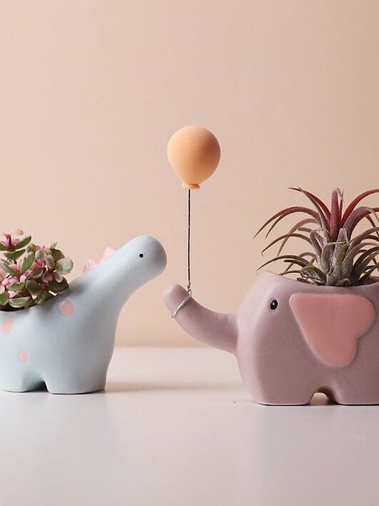 Cute dinosaur and elephant planters with succulents and balloon, perfect for whimsical decor ideas.