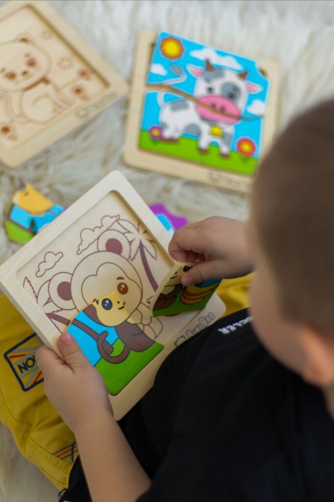 Child playing with colorful animal puzzle on a fluffy rug.