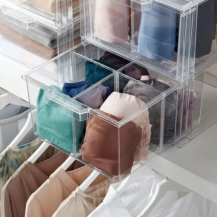 Clear storage boxes with neatly organized clothes, enhancing closet organization and maximizing space efficiency.